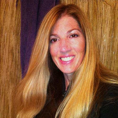 A woman with long blonde hair smiling for the camera.